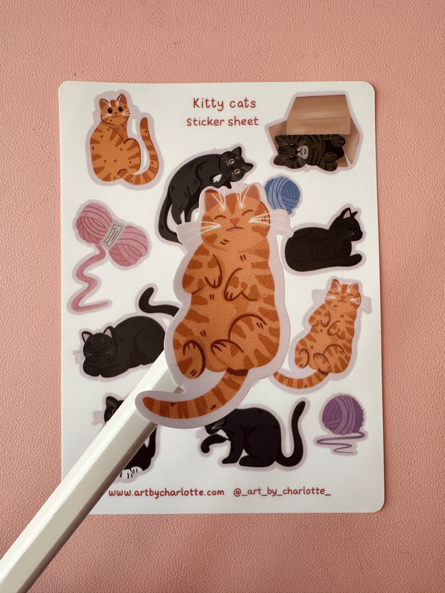 Sticker sheet with cartoon cats and related items on a pink background
