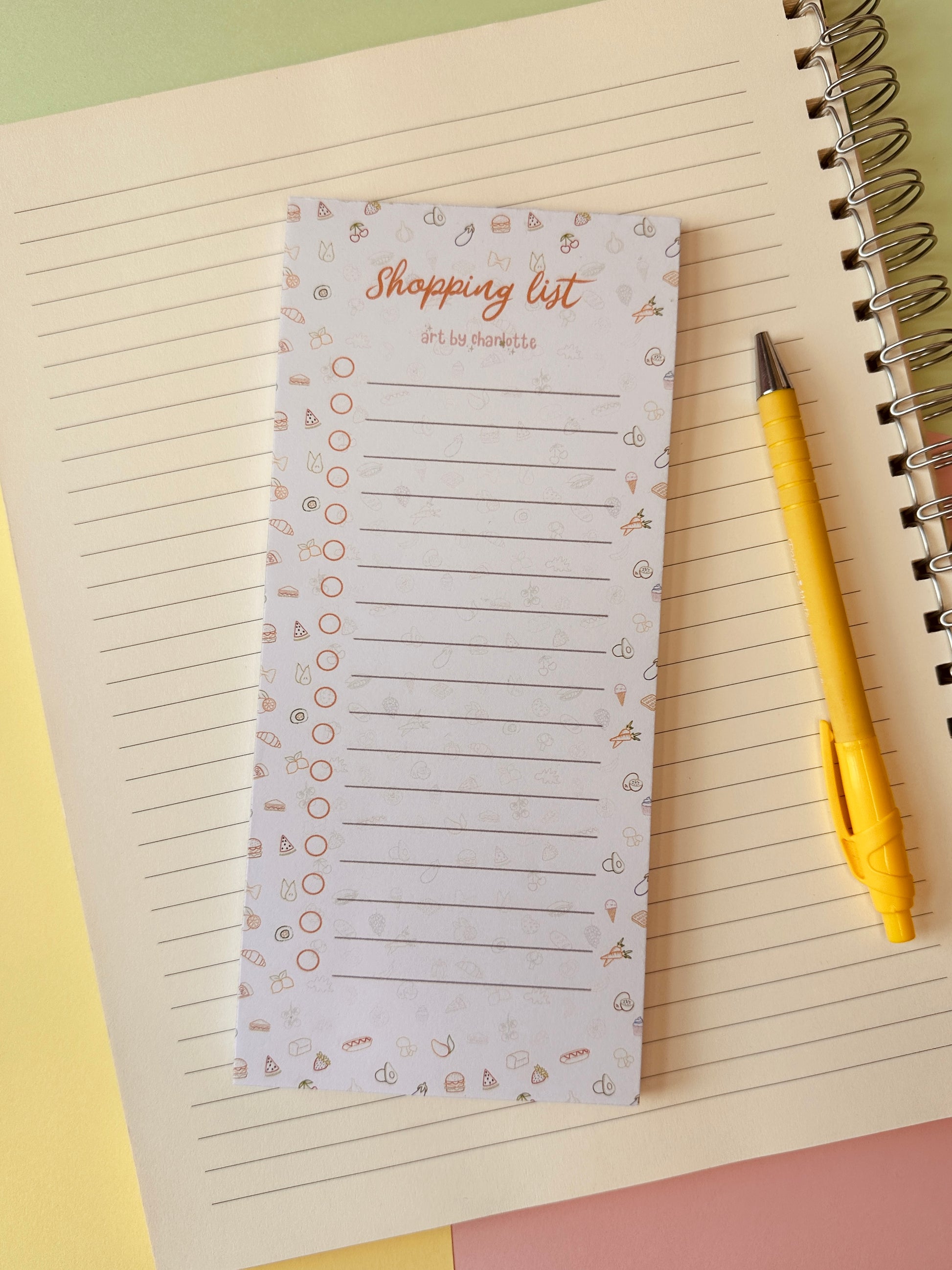 Notepad with 'Shopping list' on a notebook with a yellow pen