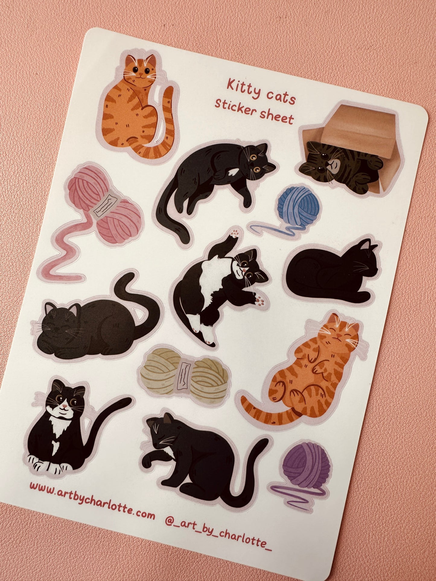 Sticker sheet with various cat illustrations and yarn balls on a pink background
