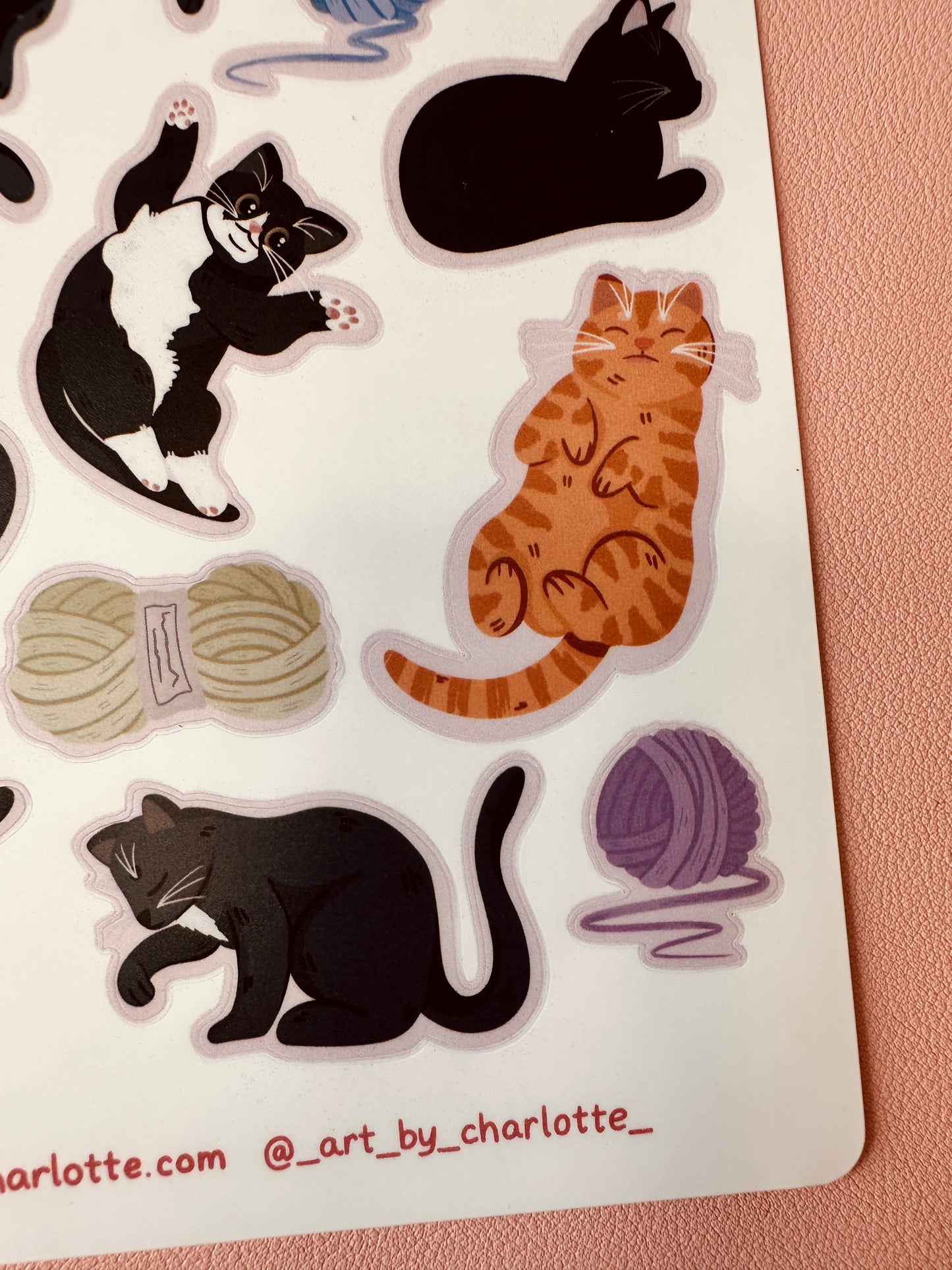 Sticker sheet with cat illustrations and yarn balls on a white background